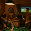 In een ruim houten tuinhuis omgetoverd tot een gezellige mancave, staat een grote pooltafel centraal.